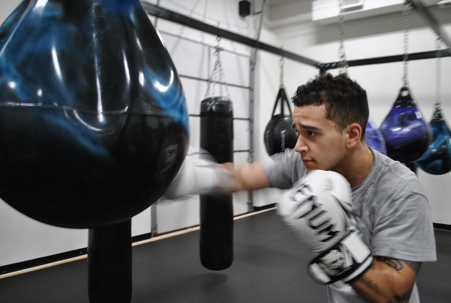 Person punching bag in gym